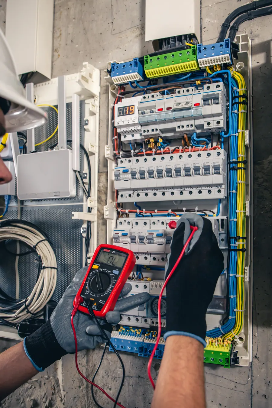 Technician working on a switchboard with fuses