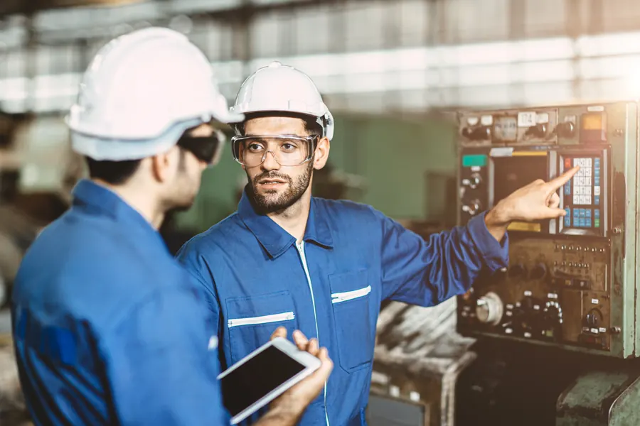 Engineer mentoring a trainee on the factory floor
