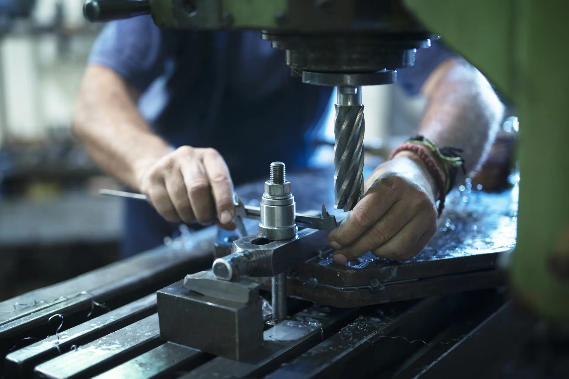 Trainee operating an industrial machine in a metal workshop